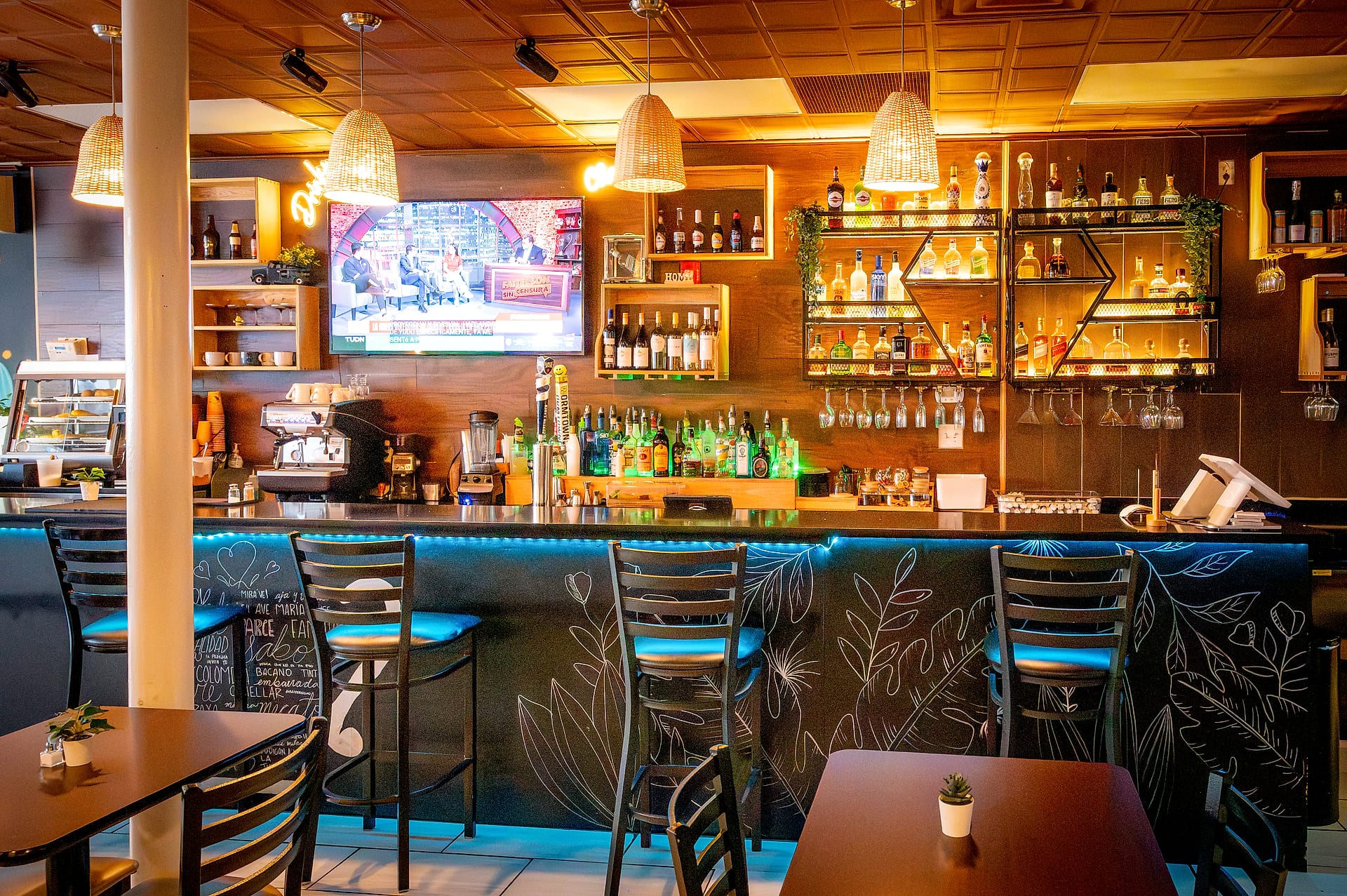 Delicias Colombianas bar interior with neon lights and full liquor wall