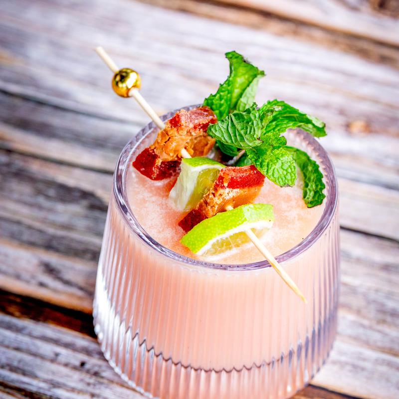 Pink frozen cocktail with mint and lime garnish